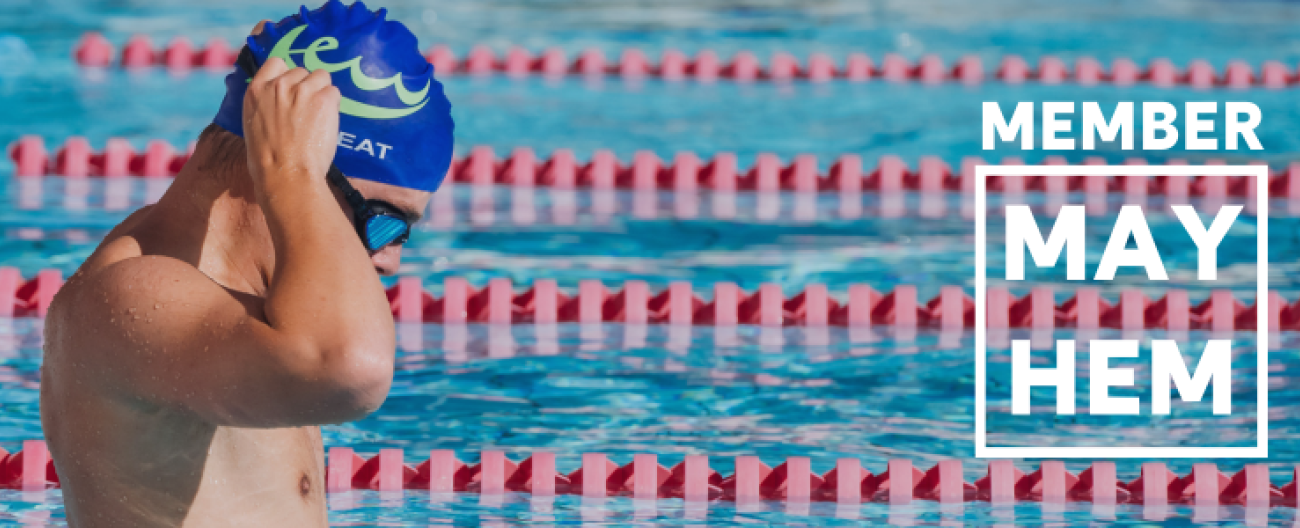Member Mayhem text overlayed onto an image of a swimmer standing up in the pool adjusting their swim cap.